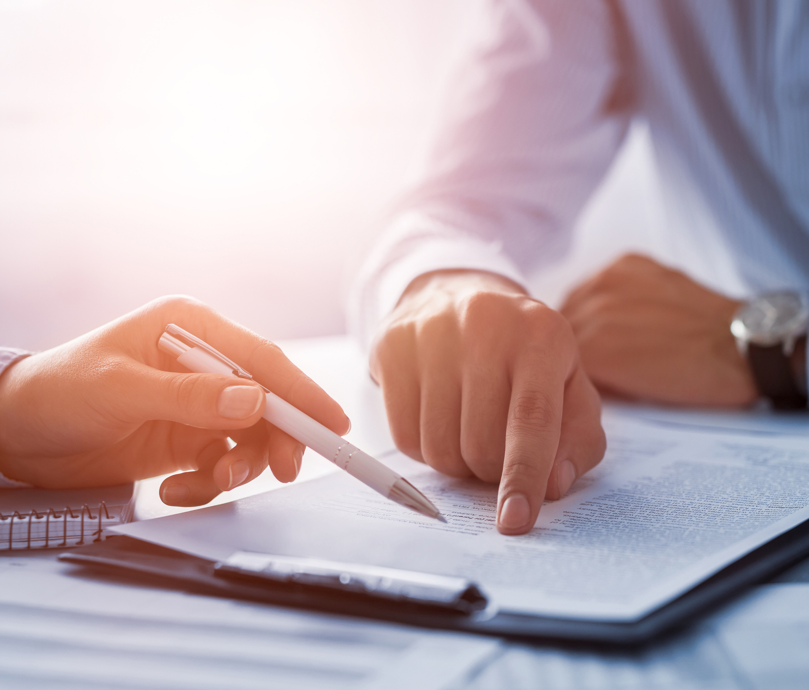 Business people negotiating a contract. Human hands working with documents at desk and signing contract.